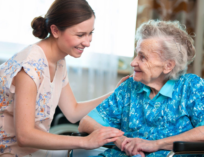 A woman and an old lady smiling for the camera.