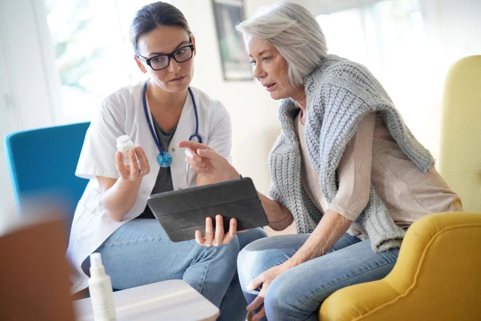 A woman and a doctor looking at something on a tablet.